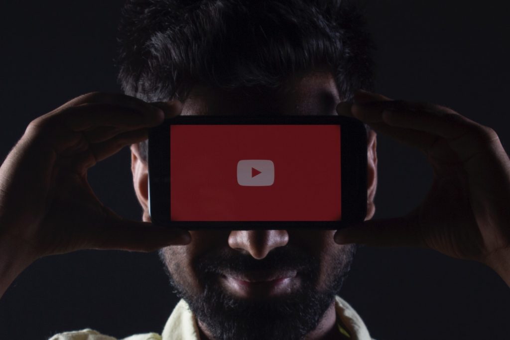 Hombre con un Android con YouTube frente a su cara